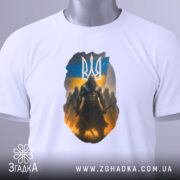 Футболка козак з тризубом, біла, зображена на столі, фон світло-сірий, принт з козаком на фоні українського прапора, з етикеткою на рукаві.