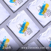 Футболка козацька воля, біла, зображена на манекені, фон світло-сірий, принт з козацьким воїном на фоні жовто-блакитних плям, текст українською мовою.