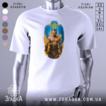 Футболка козацький дух, біла, зображена на манекені, фон світло-сірий, принт з зображенням чоловіка з мускулатурою на фоні жовто-блакитного щита.