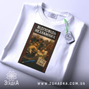 Футболка козацький гумор лист, біла футболка, складена на столі, з принтом на грудях, який зображає картину з групою людей, що обговорюють щось, на фоні світло-сірий колір, принт оформлений в рамці з червоним узором, на футболці є етикетка.