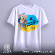 Футболка країна вільних, біла, зображена на вішалці, фон світло-сірий, принт з ведмедиком у сонцезахисних окулярах, з автоматом і гелікоптером, текст "Країна сильних! I ♥ UA" у жовто-блакитному кольорі.