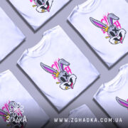 Футболка крейзі заєць, біла, зображена на манекені, фон світло-сірий, принт з веселим зайцем з короною, яскраві кольори, деталі принта включають рожеві та жовті елементи.