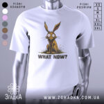 Футболка кролик карикатура, біла, зображена з фронтального ракурсу, на нейтральному фоні, принт з кроликом з великими очима та текстом 'WHAT NOW?' під ним.