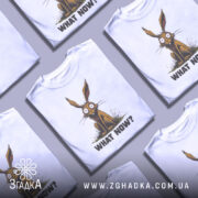 Футболка кролик карикатура, біла, зображена з фронтального ракурсу, на нейтральному фоні, принт з кроликом з великими очима та текстом 'WHAT NOW?' під ним.