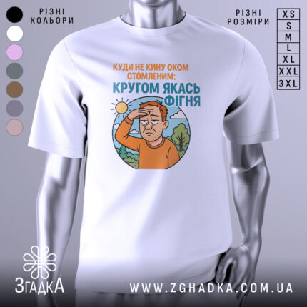 Футболка кругом якась фігня, біла футболка на манекені, ракурс спереду, фон нейтральний, принт з зображенням чоловіка з рудим волоссям, який прикриває очі від сонця, текст зверху оранжевого кольору, текст внизу блакитного кольору.
