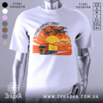 Футболка кримський міст горить, біла, зображена на манекені, фон нейтральний, принт зображає вантажівку та дрони на фоні палаючого мосту з оранжевими та червоними відтінками.