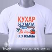 Футболка кухар без мата, біла, зображена зверху, фон світло-сірий, принт містить текст "КУХАР БЕЗ МАТА" з ілюстрацією ножа та помідора, на футболці є етикетка.