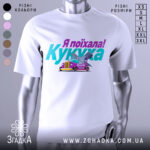 Футболка кукуха поїхала, біла, зображена з фронтального ракурсу, на фоні світло-сірого кольору, принт містить текст "Я поїхала! Кукуха" та малюнок автомобіля з птахом.