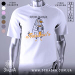 Футболка кукуха сказала поїхали. Біла футболка з коротким рукавом, зображення птаха в білому халаті, що тримає планшет. Принт виконаний у яскравих кольорах, текст на футболці говорить 'Поїхали!'. Фон нейтральний, з легким градієнтом.