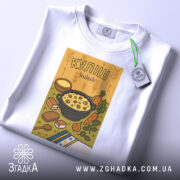 Футболка куліш білого кольору, зображена зверху, на фоні світлого кольору. Принт з ілюстрацією кулішу, що містить каструлю з їжею, овочі та хліб, з прикріпленою етикеткою.