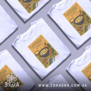 Футболка куліш білого кольору, зображена з фронтального ракурсу, на фоні світло-сірого кольору. Принт з ілюстрацією кулішу, що містить каструлю з їжею, овочі та хліб, оформлений у яскравих кольорах.