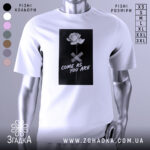 Футболка квітка монохром, біла, зображена на манекені, фон світло-сірий, принт з чорним фоном, білою трояндою та написом 'COME AS YOU ARE'.