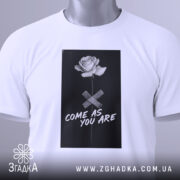 Футболка квітка монохром, біла, складена на поверхні, фон світло-сірий, принт з чорним фоном, білою трояндою та написом 'COME AS YOU ARE', з етикеткою зеленого кольору.