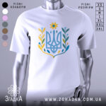 Футболка квітковий тризуб, біла, зображена з правого ракурсу на манекені, фон світло-сірий, принт у вигляді тризуба з квітковими елементами в жовтих, блакитних та зелених відтінках.
