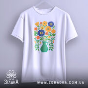 Футболка квіти Україна, біла футболка, підвішена на вішалці, з принтом букету квітів у вазі, яскраві кольори, фон світло-сірий, ракурс спереду.