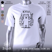 Футболка київський ведмідь, біла, зображена на манекені, фон світло-сірий, принт з ведмедем та архітектурними елементами Києва, напис 'KYIV' над ведмедем.