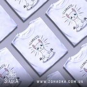 Футболка лама Бердичів, біла, зображена на манекені, фон світло-сірий, принт з лами в позі медитації з написом 'LLAMASTE' над нею.