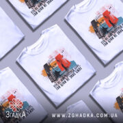 Футболка Леся Українка, білого кольору, зображена з правого ракурсу на манекені, фон нейтральний, принт містить портрет Лесі Українки з кольоровими акцентами та текстом.