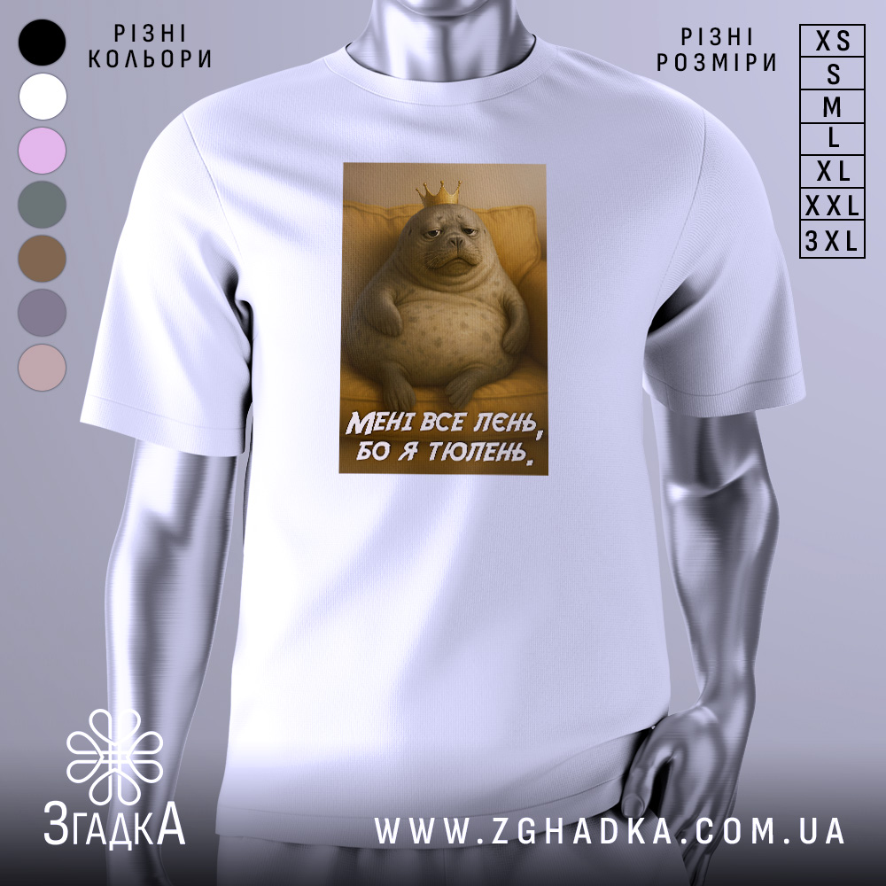 Футболка лєнь я тюлень, біла футболка з принтом, зображення тюленя з короною на фоні жовтого дивану, текст на футболці: 'МЕНІ ВСЕ ЛЄНЬ, БО Я ТЮЛЕНЬ'.
