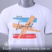 Футболка лімітована колекція, біла, зображена зверху, фон світло-сірий, принт з кольоровими мазками: блакитним, персиковим та червоним, текст 'you're Limited edition' написаний чорним шрифтом, на футболці є етикетка з зеленим шнурком.