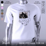 Футболка люблю мого кота, білого кольору, зображена на манекені, фон світло-сірий, принт з чорно-білим зображенням кота та написом 'LOVE my cat' у стилі рукописного шрифту.