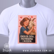 Футболка любов зла, складена на столі, з білим кольором та яскравим принтом. На футболці зображена дівчина, яка обіймає козу, з сердечками навколо. На футболці є етикетка з логотипом, що підкреслює стиль.