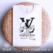 Футболка louis vuitton білого кольору, складена на плетеній основі, фон світло-сірий, принт з персонажем у вбранні з логотипом LV, що виконує жест.