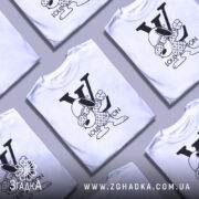 Футболка louis vuitton білого кольору, зображена на манекені з правого ракурсу, фон світло-сірий, принт з персонажем у вбранні з логотипом LV, що виконує жест.