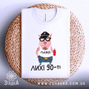 Футболка лихі 90, біла, складена на плетеній основі, фон білий, принт з мультяшним поросям у кепці та сонцезахисних окулярах, з написом 'МАФІЯ' на футболці.