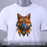 Футболка лис воїн білого кольору, складена на поверхні, ракурс зверху, фон світло-сірий, принт з лисом у національних кольорах, з етикеткою, що звисає.