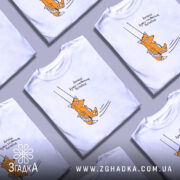 Футболка лисичка качайся, біла футболка на манекені, з принтом лисички, що сидить на гойдалці, фон світло-сірий, деталі принта яскраві, текст українською мовою.