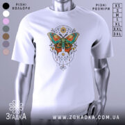 Футболка магія метелика білого кольору, зображена з фронтального ракурсу на манекені, фон світло-сірий, принт з метеликом в яскравих кольорах, оточений декоративними елементами.