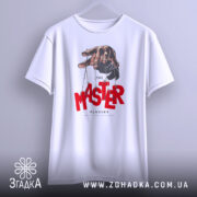 Футболка майстер планів, білого кольору, підвішена на вішалці, фон світло-сірий, принт з рукою, що тримає ляльку, червоний текст 'MASTER' та чорний 'PLANNER'.