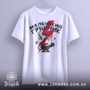 Футболка маленький грішник, біла, підвішена на вішалці, фон світло-сірий, принт з червоним і чорним малюнком маленького диявола з рогами та написом.