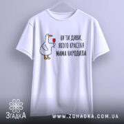 Футболка мама красеня народила, біла, підвішена на вішалці, фон світло-сірий, принт з качкою, що тримає келих, текст чорний.