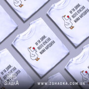 Футболка мама красеня народила, біла, зображена на манекені, фон світло-сірий, принт з качкою, що тримає келих, текст чорний.