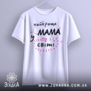 Футболка мама у світі, біла, зображена на вішалці, фон світло-сірий, принт чорний з рожевими елементами та сердечками, текст говорить 'найкраща мама у світі'.