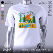 Футболка мандруй гори, біла, зображена на манекені, фон світло-сірий, принт з горами, деревами та річкою в яскравих кольорах.