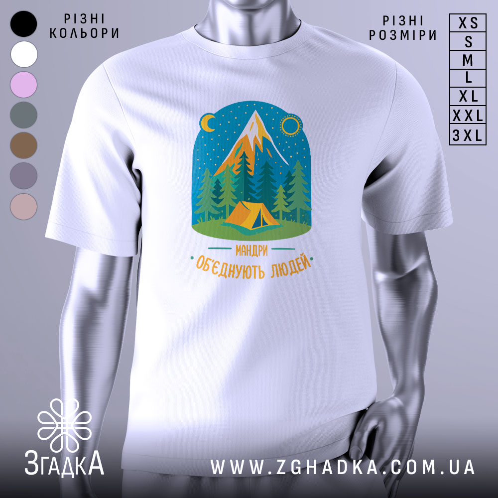 Футболка мандри обʼєднують білого кольору, зображена на манекені з блискучою поверхнею, фон нейтральний сірий. Принт містить малюнок гір, лісу та намету, виконаний у яскравих кольорах з текстом 'Мандри обʼєднують людей'.