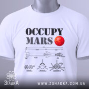 Футболка Марс колонізує біла, складена на поверхні, з принтом 'OCCUPY MARS' та червоною планетою, з зеленим ярликом, на фоні світло-сірого градієнту.