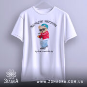 Футболка мастодонт мікрофона білого кольору, зображена з фронтального ракурсу, фон світло-сірий, принт з ведмедиком у червоній куртці та синій кепці, що тримає мікрофон, текст під принтом: "кринж стендапу".