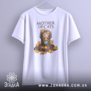 Футболка мати котів білого кольору, підвішена на вішалці, фон градієнтний сірий, принт з малюнком дівчини на троні з котами, напис 'MOTHER OF CATS' зверху.