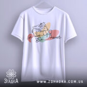 Футболка медовий настрій, біла, підвішена на вішалці, зображена з фронтального ракурсу, фон світло-сірий, принт з малюнком персонажа, що тримає банку з медом, з написом 'love sweet'.