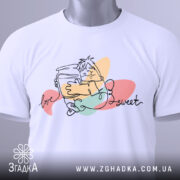 Футболка медовий настрій, біла, зображена зверху, на фоні світло-сірого кольору, принт з малюнком персонажа, що тримає банку з медом, з написом 'love sweet', на комірці видна етикетка.