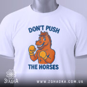 Футболка мем Не жени коней, складена біла футболка з принтом, зображення коня в боксерських рукавичках, ракурс зверху, фон світлий, текст синього кольору, на футболці є етикетка.