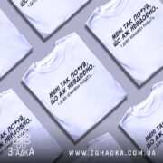 Футболка мені так по*уй, біла футболка на манекені, з чорним принтом, текст на грудях: 'МЕНІ ТАК ПО*УЙ, ЩО АЖ НЕВДОБНО. І ДАЖЕ НЕМНОЖКО ПОБЛЯТЬ...'. Фон світло-сірий.