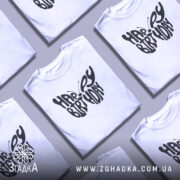 Футболка метелик вітання, біла, зображена на манекені з бокового ракурсу, фон світло-сірий, принт чорного кольору з написом 'HAPPY BIRTHDAY' у формі метелика.