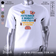 Футболка метелики в животі, білого кольору, зображена на манекені, фон нейтральний, принт містить текст та малюнки метеликів і мозку.