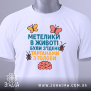 Футболка метелики в животі, білого кольору, зображена на манекені, фон нейтральний, принт містить текст та малюнки метеликів і мозку.