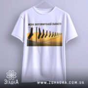 Футболка межа Житомирської області, білого кольору, підвішена на вішалці, фон нейтральний, принт з шкарпетками на мотузці, пейзаж з жовтими та зеленими відтінками.